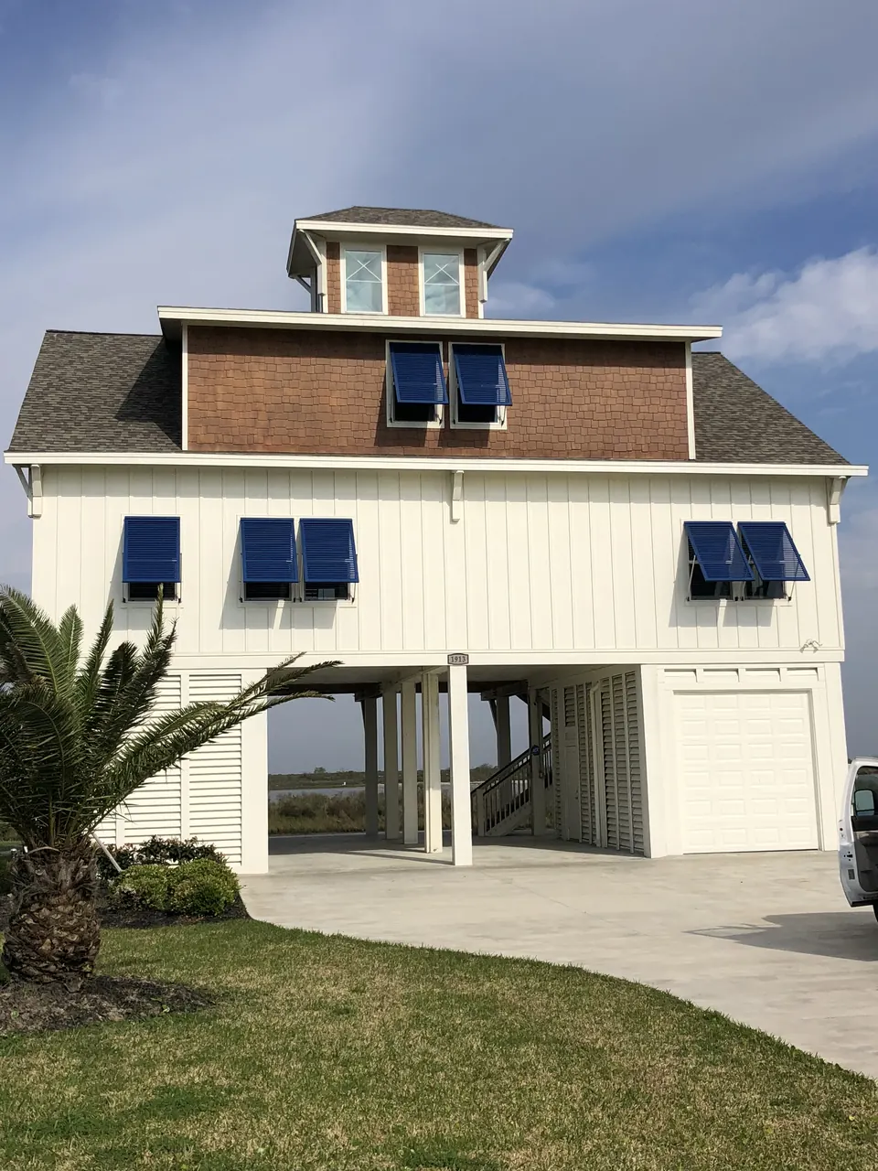 Navy Bahama shutters on a white beach house on pilings on Bolivar Peninsula