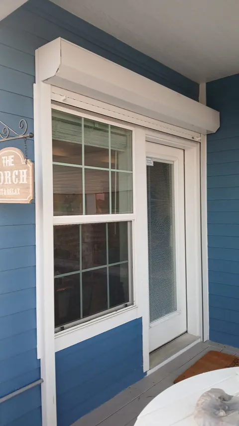 Roll-down shutter housing above a porch door and window on a Bolivar Peninsula beach house