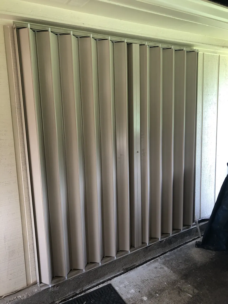 Close view of closed accordion shutter blades on a home in Dickinson
