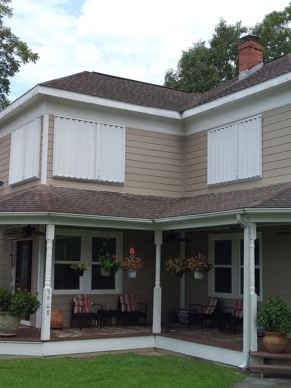 The same Dickinson house with accordion shutters closed over its upper windows