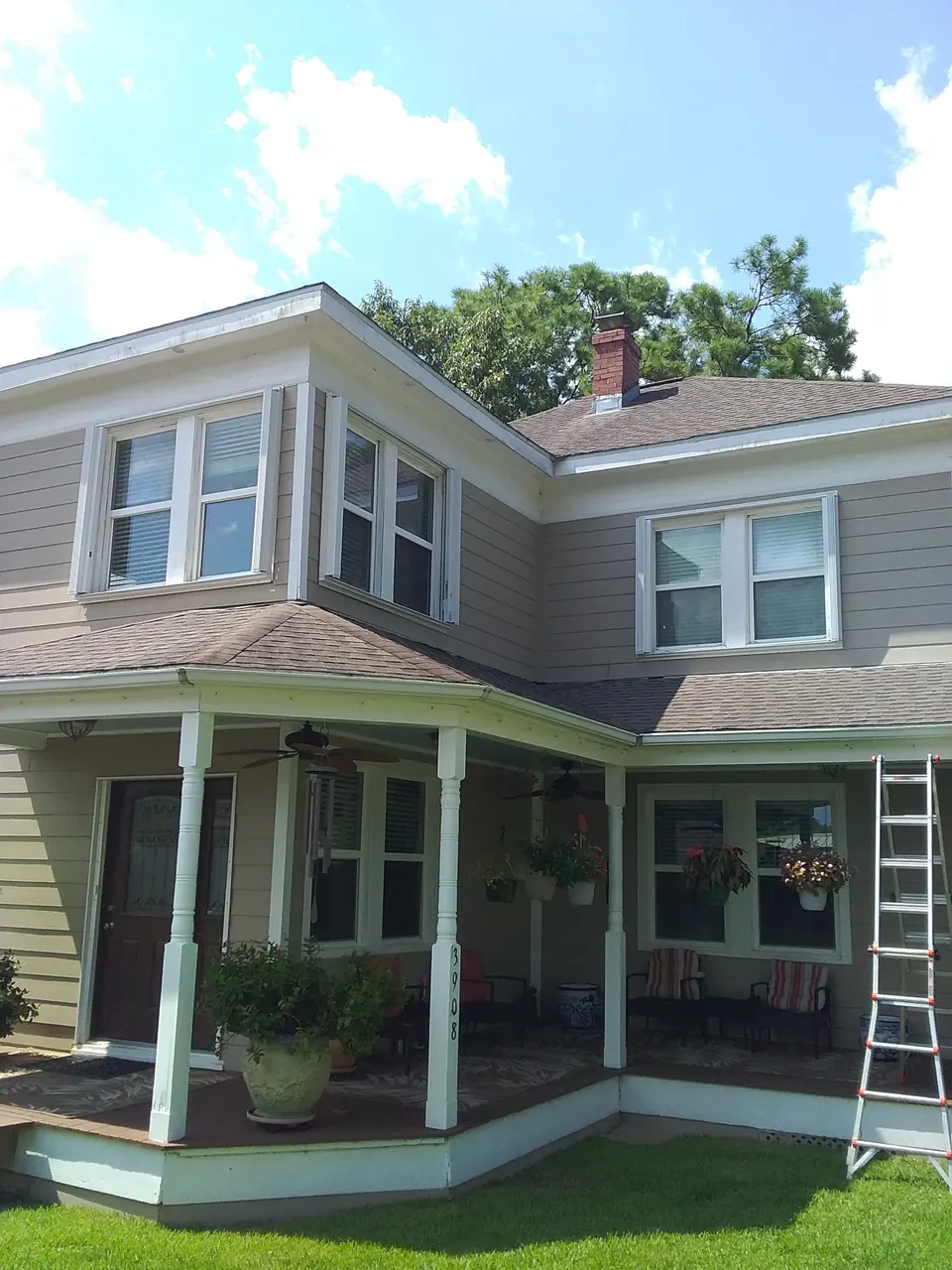 A two-story porch house in Dickinson with its accordion shutters folded open