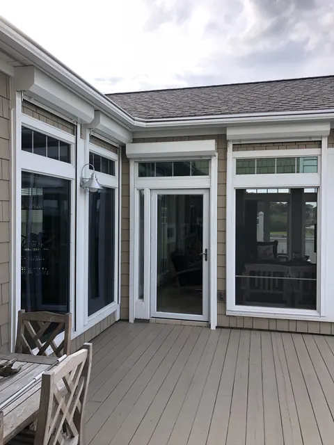 Roll-down shutter housings above the windows and door of a deck in Kemah