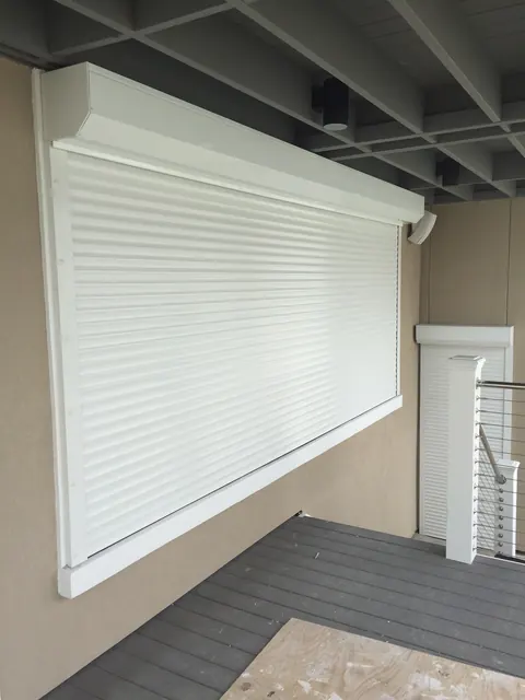 White roll-down shutter closed over a wide opening under a deck in Kemah