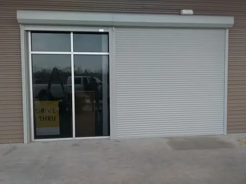 A roll-down shutter beside the drive-thru window of a business in Kemah