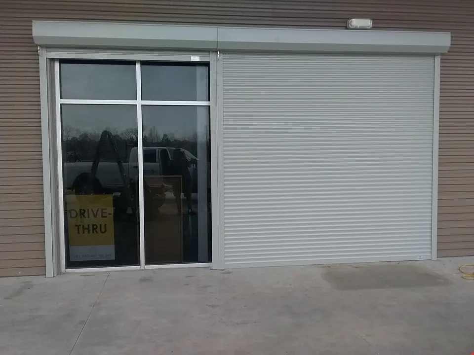 A roll-down shutter beside the drive-thru window of a business in Kemah