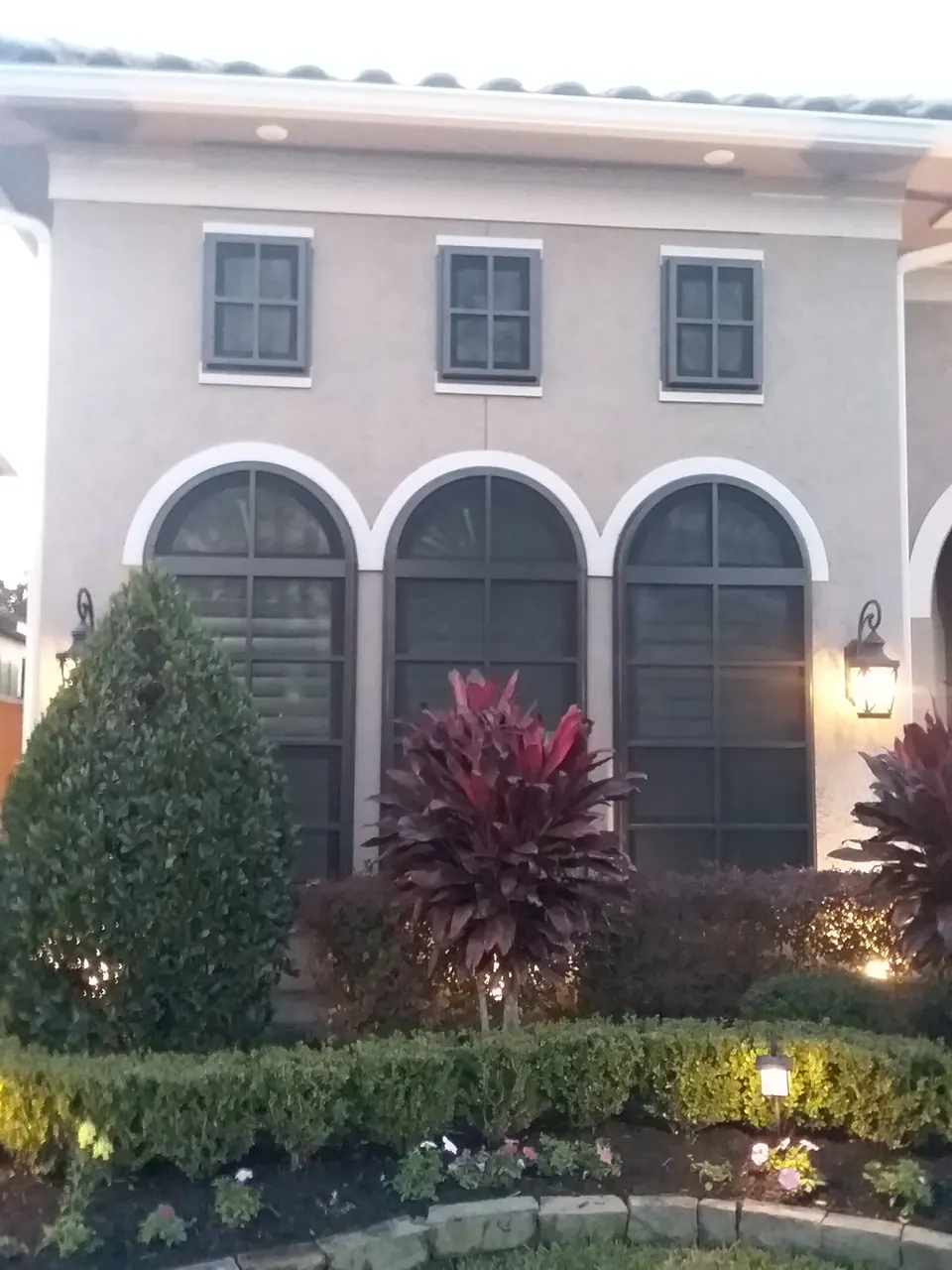 TAPCO screens over the arched windows of a two-story stucco home in League City