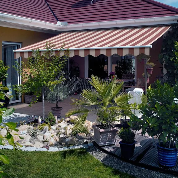 red and white striped awning over landscaped backyard patio space