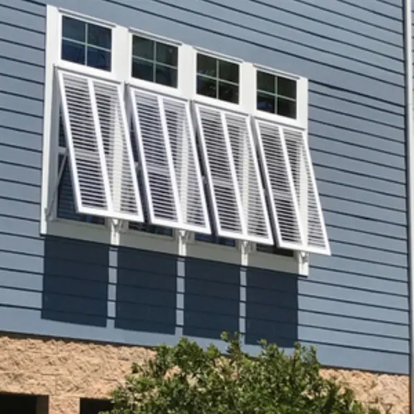 Bahama shutters on the outside of four windows