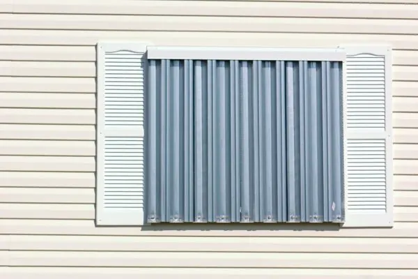 Corrugated aluminum hurricane panels fastened over a window