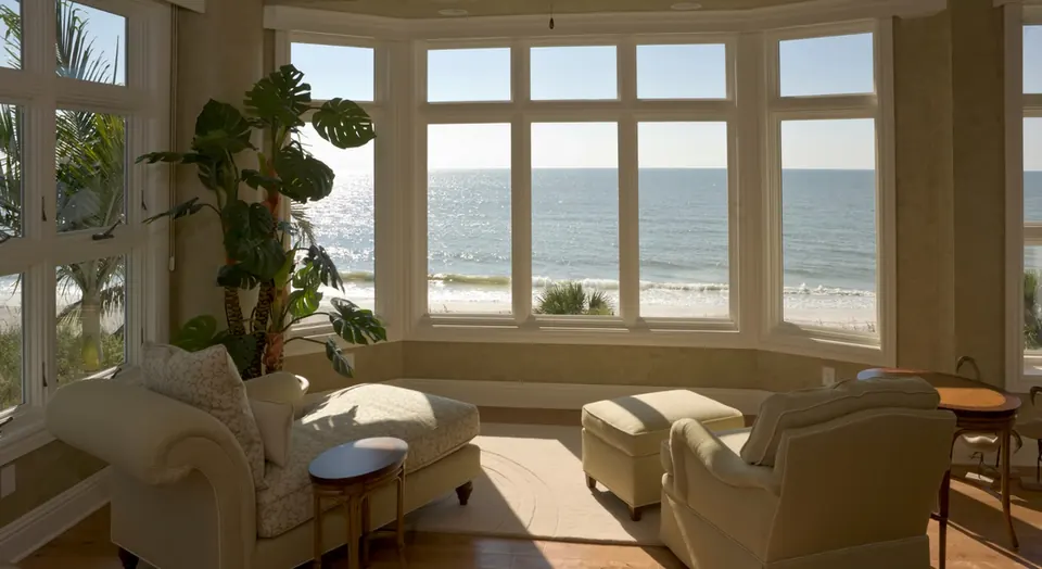 Sunlit beach house living room with tall windows facing the Gulf